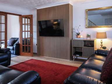 A living room with a television and a sofa at Penrhos Walks Holyhead