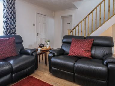 A living room with leather sofas and a table at Penrhos Walks in Holyhead
