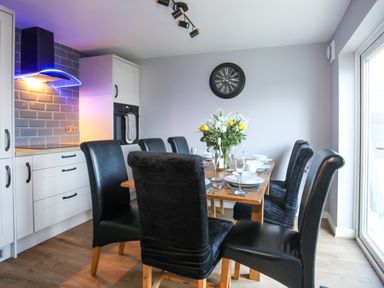 A dining room with a table set for meals at Penrhos Walks in Holyhead