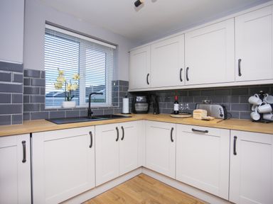 A kitchen with a sink and wooden countertop at Penrhos Walks in Holyhead