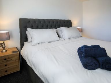 A bedroom with a bed and bedside table at Penrhos Walks Holyhead