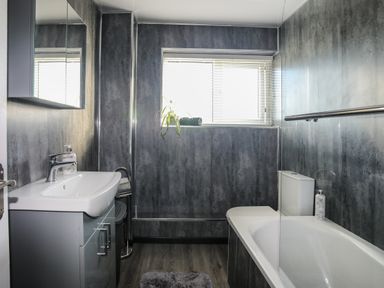 A bathroom with a bathtub, sink, and toilet at Penrhos Walks Holyhead