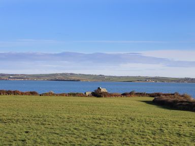 A view of water and grass fields at Penrhos Walks Holyhead