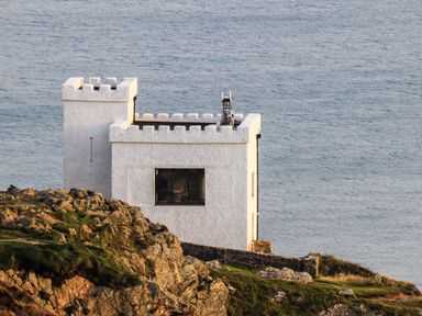 A white building resembling a castle by the ocean at Penrhos Walks in Holyhead