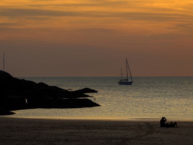A beach scene with a boat on the water at Penrhos Walks in Holyhead