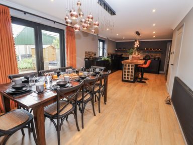A dining room with a large table and kitchen island at Holly Farm near Brantham
