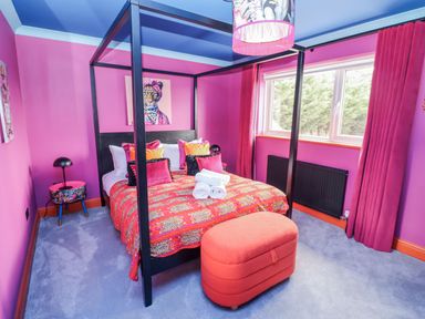 A bedroom with a four-poster bed and a window at Holly Farm near Brantham