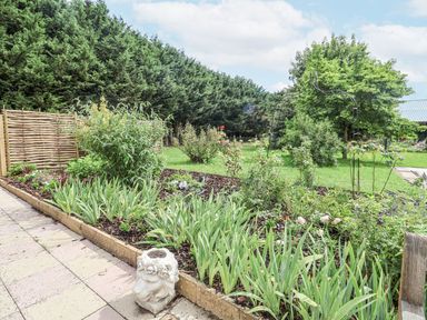 A garden with flowers and a decorative sculpture at Holly Farm near Brantham