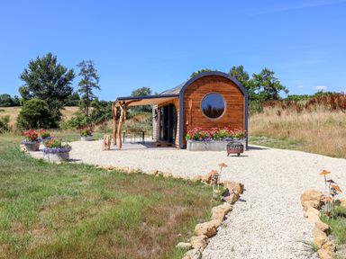 A house with a gravel path and flower pots at Bugley Pools Hideaway in Bugley near Gillingham