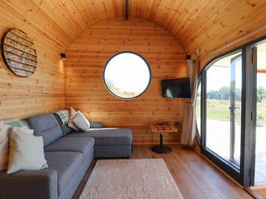 A sitting area with a sofa and a window at Bugley Pools Hideaway in Bugley near Gillingham