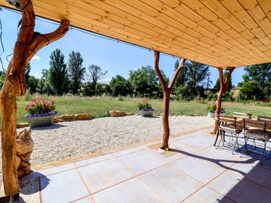 An outdoor seating area with wooden posts and planters at Bugley Pools Hideaway in Bugley near Gillingham