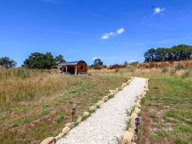 A gravel path leading to a pod-style structure at Bugley Pools Hideaway in Bugley near Gillingham