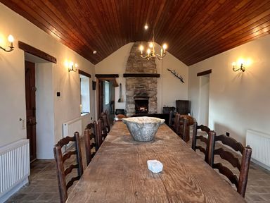 A dining room with a wooden table and chairs at Cobble Stone Cottage near Leabgarrow, County Donegal
