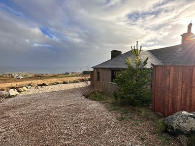 An outdoor view of a house with a gravel driveway at Cobble Stone Cottage near Leabgarrow, County Donegal