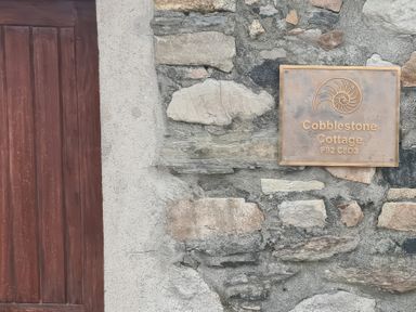 A sign for Cobblestone Cottage on a stone wall near Leabgarrow, County Donegal