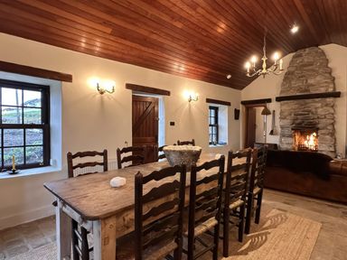 A dining room with a wooden table and chairs at Cobble Stone Cottage near Leabgarrow, County Donegal
