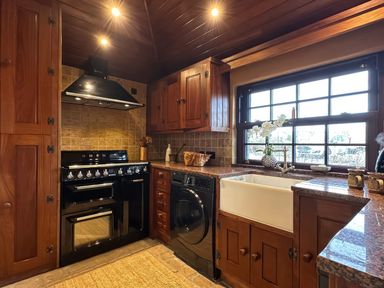 A kitchen with an oven, sink and dishwasher at Cobble Stone Cottage near Leabgarrow, County Donegal