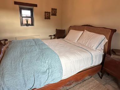 A bedroom with a bed and window at Cobble Stone Cottage near Leabgarrow, County Donegal