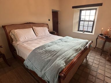 A bedroom with a bed and window at Cobble Stone Cottage near Leabgarrow, County Donegal