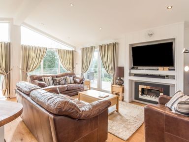 A living room with a sofa and television at 2 Tree Tops in Lanreath