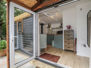 A kitchen with a view of the outside at Charltons Hollow Cabin in Haywards Heath