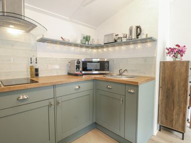 A kitchen with sink, microwave, and coffee machine at Charltons Hollow Cabin, Haywards Heath