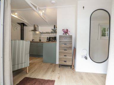A kitchen area with seating and storage at Charltons Hollow Cabin Haywards Heath