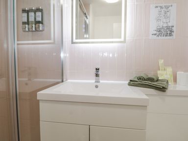 A bathroom with a sink and towels at Charltons Hollow Cabin in Haywards Heath