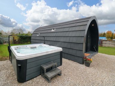 An outdoor area featuring a hot tub beside a building at Bumblebee Glamping Pod in Malton
