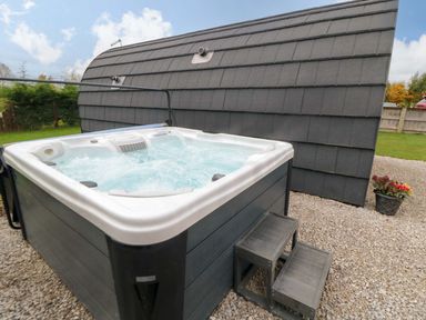 A hot tub with steps next to a shed at Bumblebee Glamping Pod in Malton