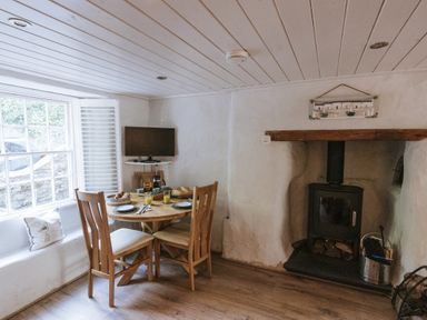 A dining room with a table and chairs at Tamarisk Cottage in St. Agnes