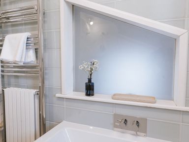 A bathroom featuring a bathtub and a towel rail at Tamarisk Cottage in St. Agnes