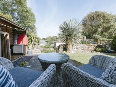 A garden with chairs and table at Tamarisk Cottage in St. Agnes