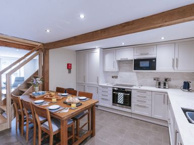 A kitchen with a dining table and appliances at Bluck's cottage in St. Agnes
