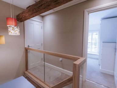 A hallway with a railing and light fixtures at Bluck's cottage St. Agnes