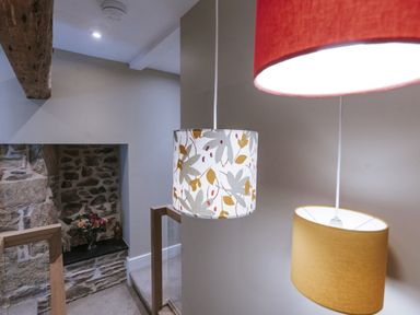 A staircase with hanging lights and a flower arrangement at Bluck's cottage St. Agnes