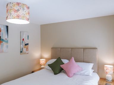 A bedroom with a bed and artwork on the wall at Bluck's cottage in St. Agnes