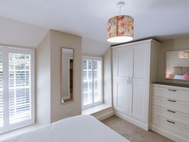 A bedroom featuring a wardrobe and a mirror at Bluck's cottage St. Agnes