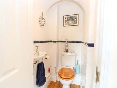 A bathroom with a toilet and sink at Honeysuckle Cottage in Swaffham