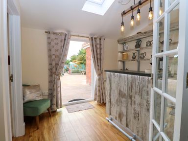 An entryway with a bar and shelves at Honeysuckle Cottage in Swaffham