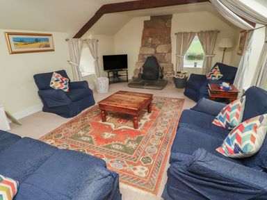 A living room with a coffee table and fireplace at Honeymug in Branton near Powburn