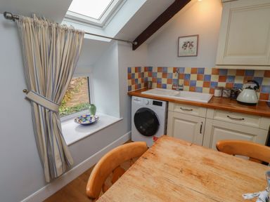 A kitchen with a table and chairs at Honeymug in Branton near Powburn