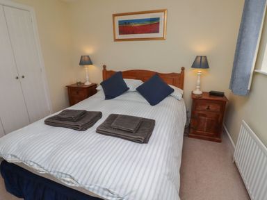 A bedroom with a bed and bedside tables at Honeymug in Branton near Powburn
