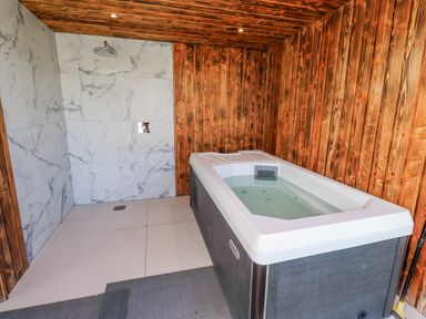 A bathroom with a bathtub and shower at Honeymug in Branton near Powburn