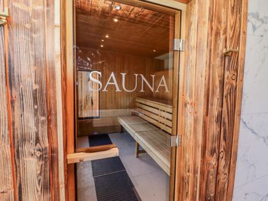 A sauna entrance with wooden benches and mats at Honeymug Branton near Powburn