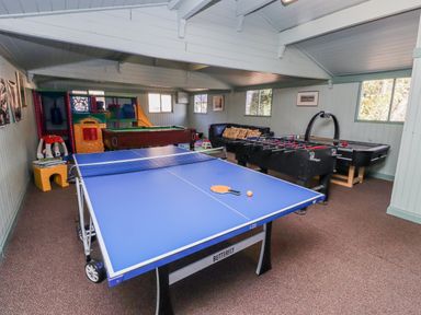 A game room with a ping pong table and foosball table at Honeymug in Branton near Powburn