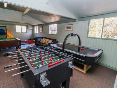 A game room with a foosball table and air hockey table at Honeymug in Branton near Powburn