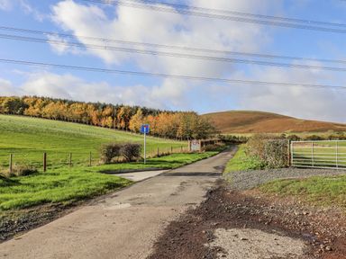 A road with a signpost and a gate at Honeymug in Branton near Powburn