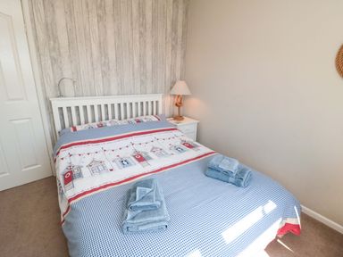 A bedroom with a bed and nightstand at Beach House