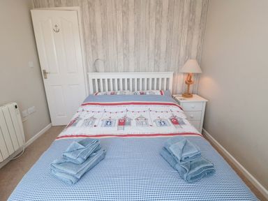 A bedroom with a bed and nightstand at Beach House
